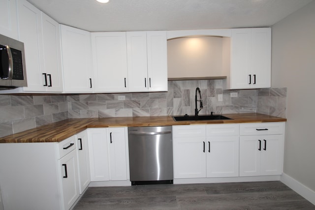 kitchen with dark wood finished floors, wood counters, stainless steel appliances, and a sink