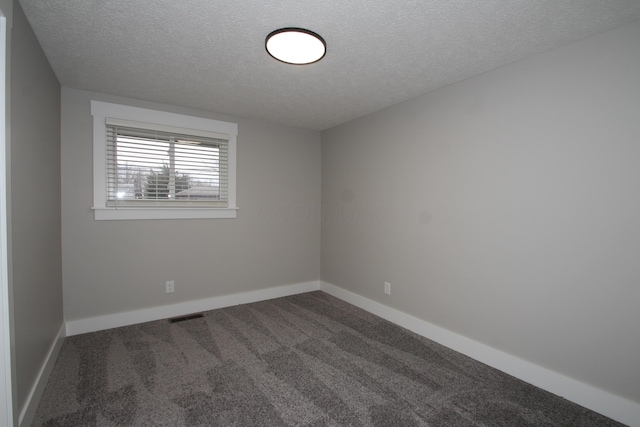 carpeted empty room featuring a textured ceiling, visible vents, and baseboards