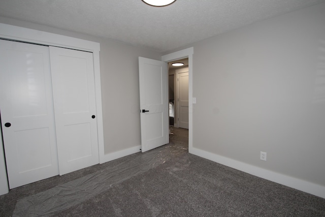 unfurnished bedroom with a closet, a textured ceiling, and baseboards