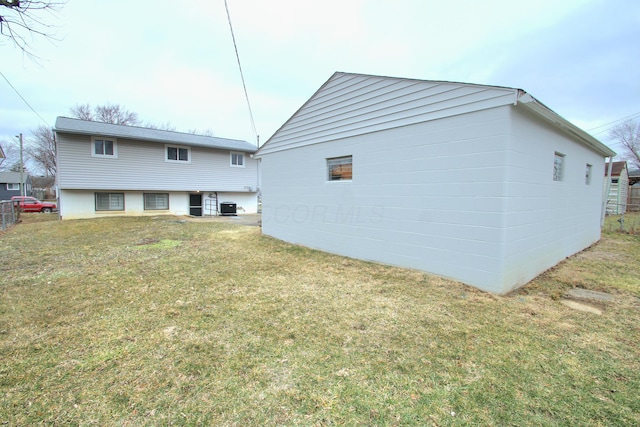 rear view of property with central AC and a lawn