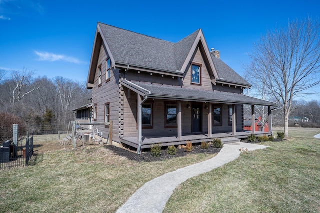 view of front of house with a chimney, a porch, roof with shingles, fence, and a front lawn