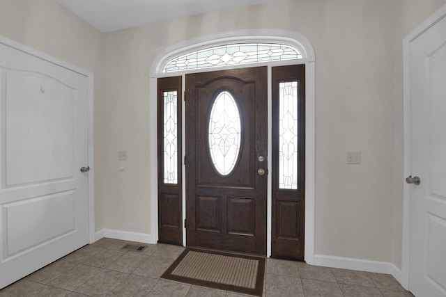 foyer entrance featuring visible vents, baseboards, and light tile patterned floors