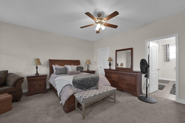 carpeted bedroom featuring ceiling fan, baseboards, and connected bathroom
