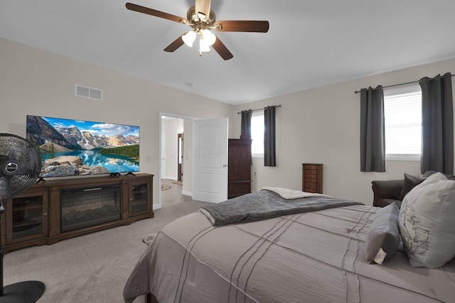 bedroom with a ceiling fan, visible vents, and light colored carpet