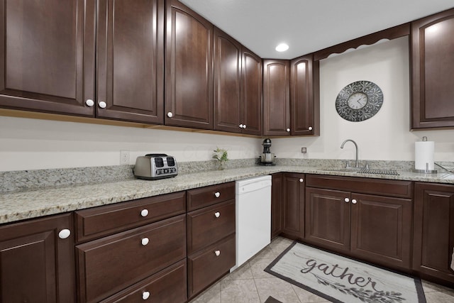 kitchen featuring light stone counters, dishwasher, a sink, and dark brown cabinets