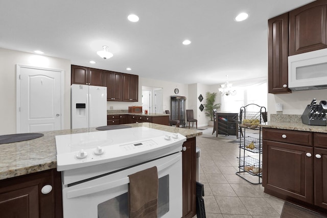 kitchen with light tile patterned floors, a chandelier, dark brown cabinetry, recessed lighting, and white appliances