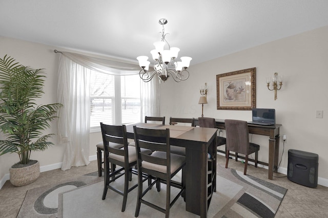 dining area featuring a chandelier and baseboards
