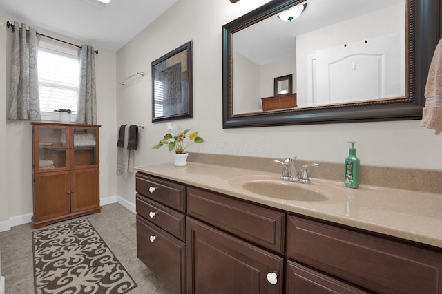 bathroom with vanity, baseboards, and tile patterned floors