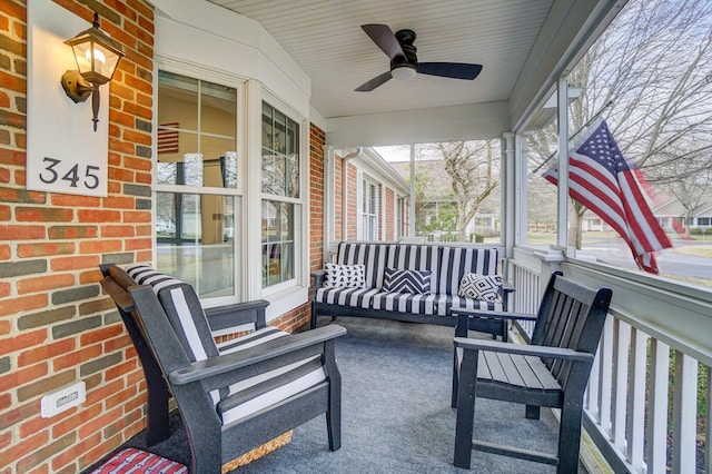 sunroom / solarium featuring a ceiling fan