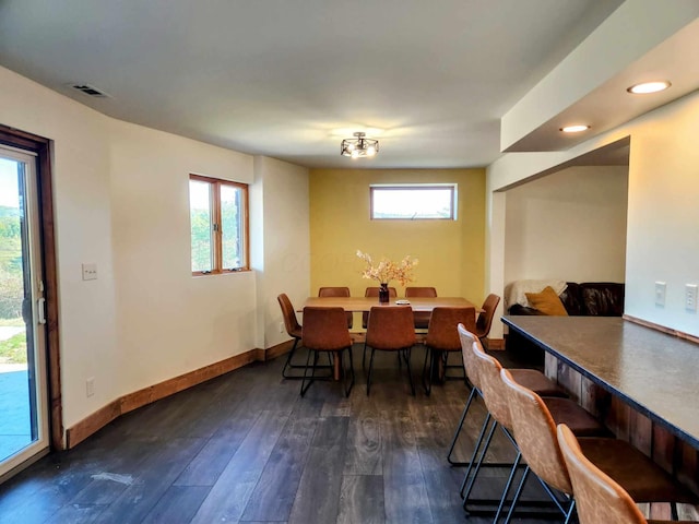 dining area with plenty of natural light, visible vents, dark wood finished floors, and baseboards