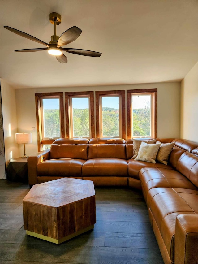 living area with a ceiling fan and dark wood finished floors