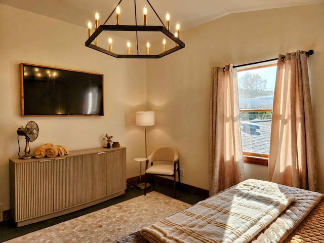 bedroom with lofted ceiling and baseboards