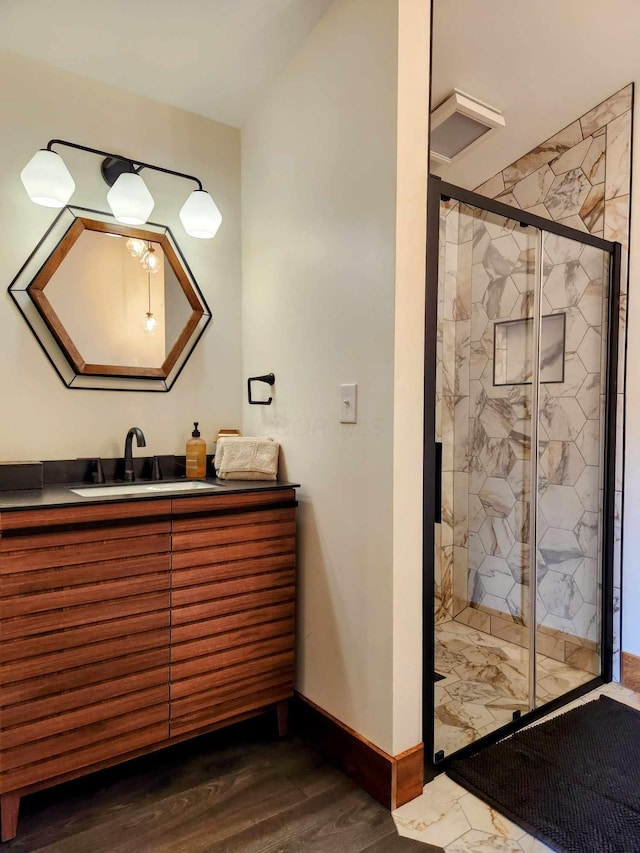 bathroom featuring a stall shower, wood finished floors, vanity, and baseboards