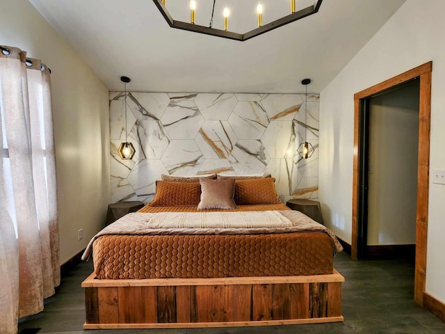 bedroom featuring an accent wall and dark wood-type flooring