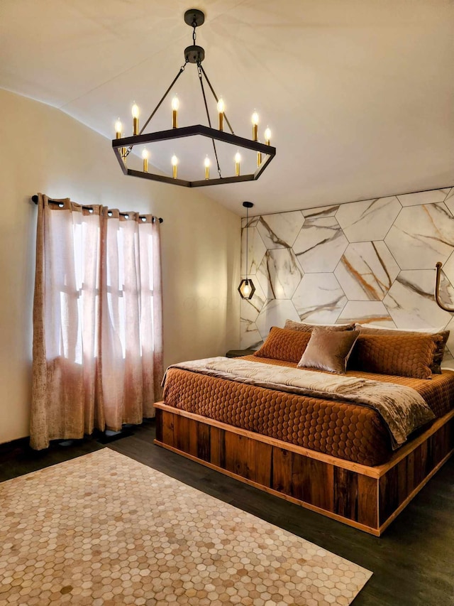 bedroom with lofted ceiling, dark wood-style flooring, and an inviting chandelier