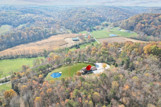 drone / aerial view with a wooded view and a rural view