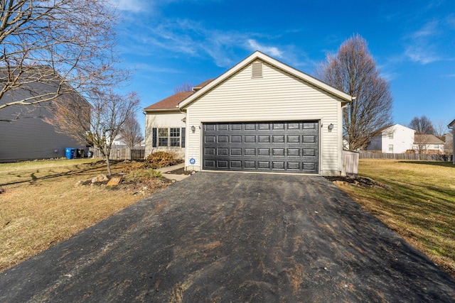 view of front of property featuring aphalt driveway, a front yard, fence, and an attached garage