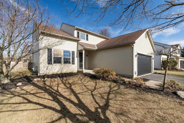 traditional-style home featuring a garage and aphalt driveway