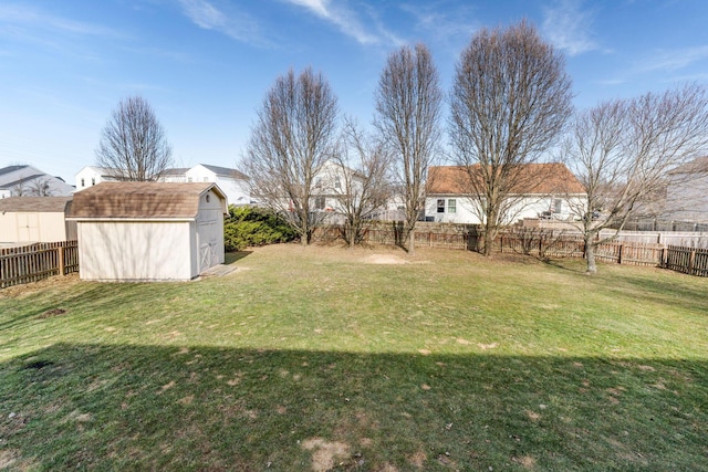 view of yard with a storage shed, an outdoor structure, and a fenced backyard