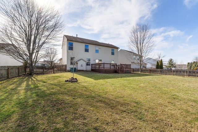 rear view of property featuring a yard, a fenced backyard, and a wooden deck