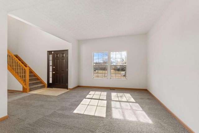 entryway with stairway, carpet flooring, and baseboards