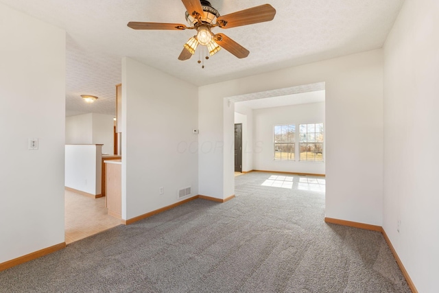 unfurnished room featuring a textured ceiling, baseboards, and carpet flooring