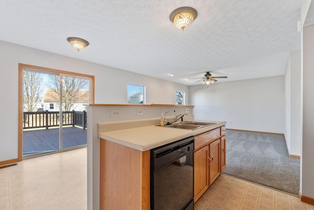 kitchen with black dishwasher, light countertops, a textured ceiling, light floors, and a sink