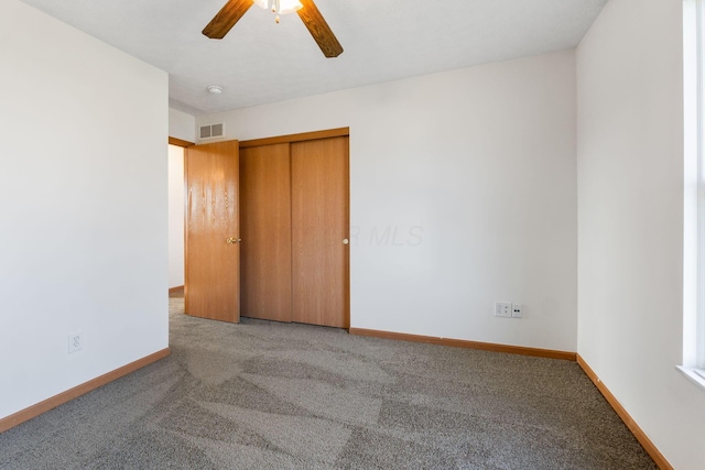 unfurnished bedroom featuring ceiling fan, light colored carpet, visible vents, baseboards, and a closet