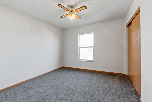 unfurnished bedroom featuring a textured ceiling, baseboards, and carpet flooring