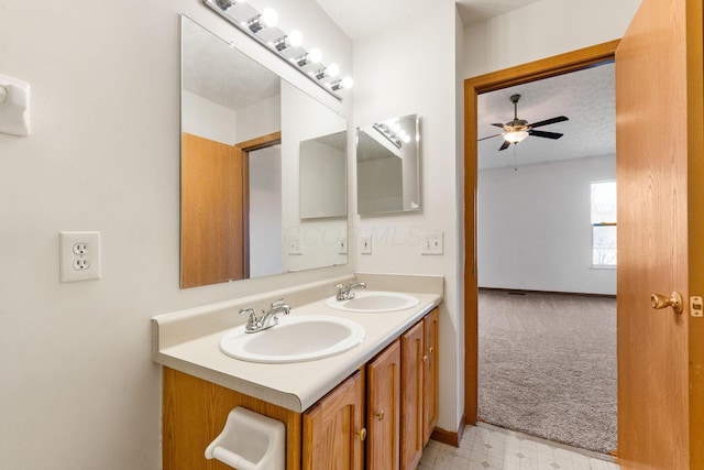 full bathroom featuring double vanity, ceiling fan, a sink, and tile patterned floors