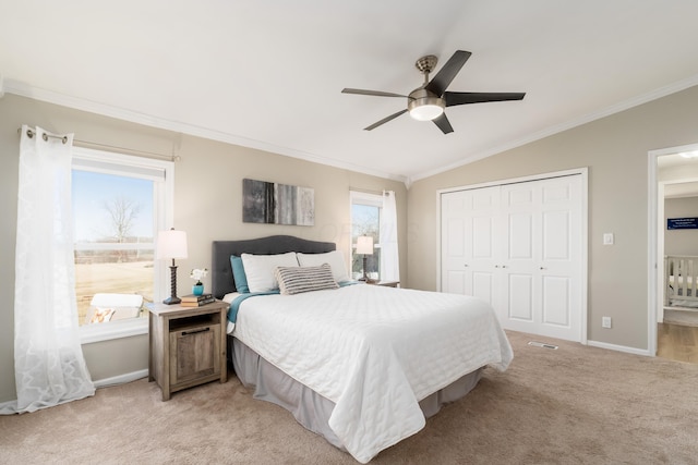 bedroom with baseboards, ornamental molding, vaulted ceiling, a closet, and light colored carpet