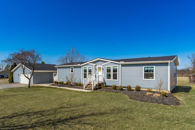 manufactured / mobile home featuring an outbuilding, concrete driveway, and a front lawn