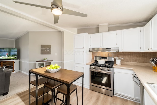 kitchen featuring light countertops, under cabinet range hood, appliances with stainless steel finishes, white cabinetry, and tasteful backsplash