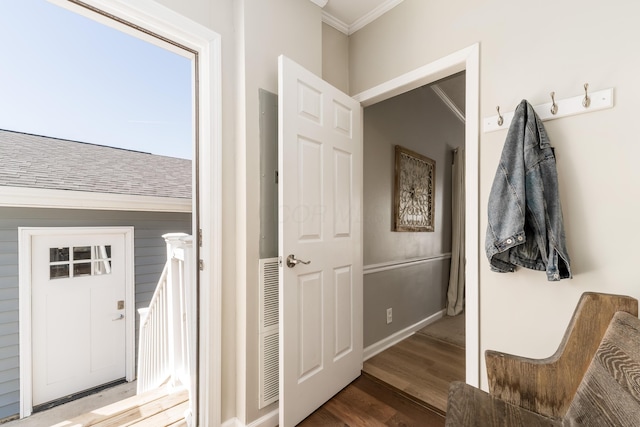 interior space with crown molding, wood finished floors, and baseboards