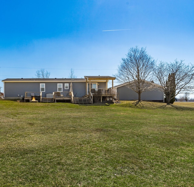 rear view of house featuring a wooden deck and a yard