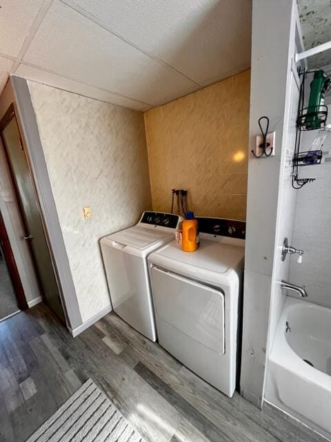 washroom with washer and dryer, laundry area, and wood finished floors