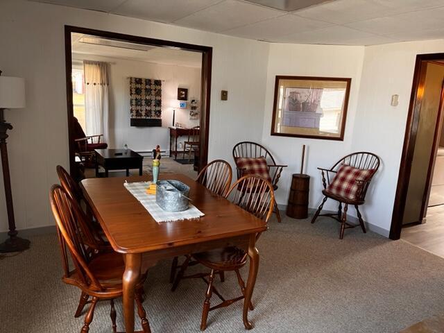 dining space with light carpet and baseboards