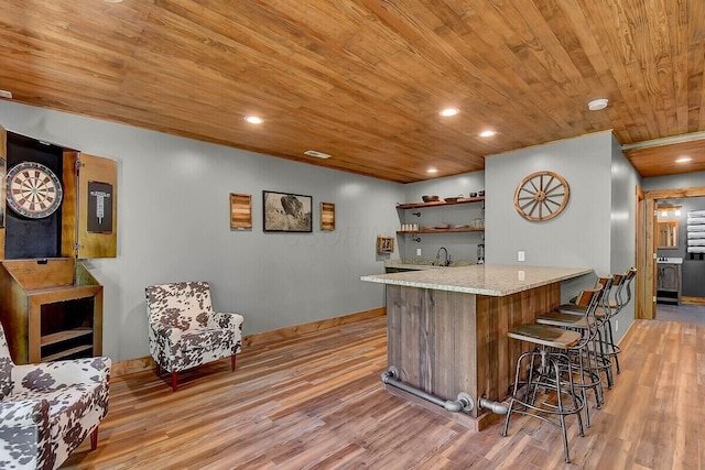 bar featuring light wood finished floors, recessed lighting, a sink, wet bar, and wooden ceiling