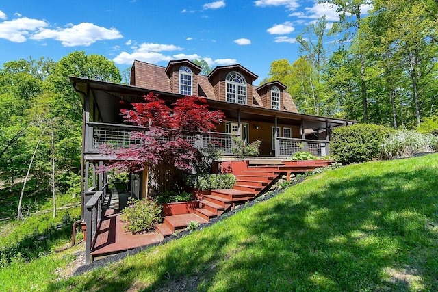 rear view of property with a yard and stairway