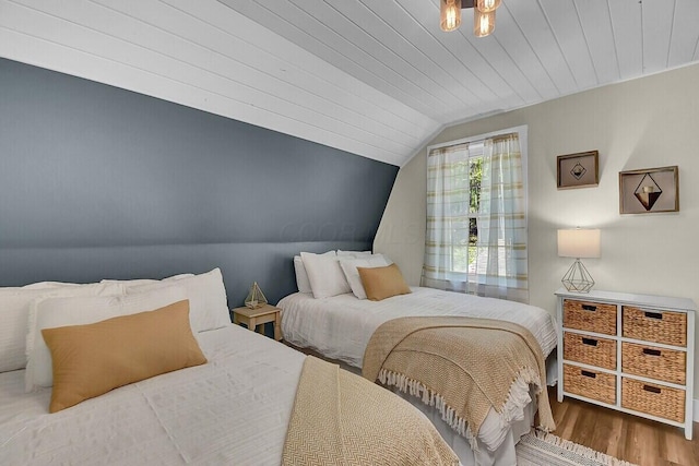 bedroom featuring lofted ceiling, wood finished floors, and wood ceiling