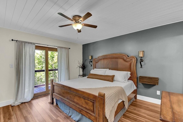 bedroom featuring a ceiling fan, access to outside, baseboards, and wood finished floors