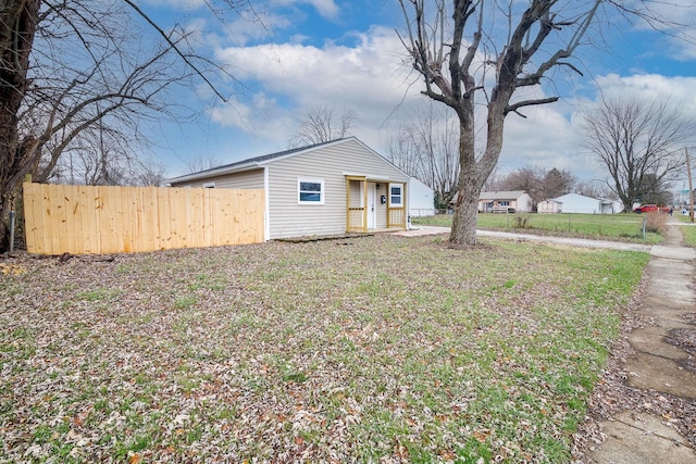 view of side of home featuring an outbuilding and fence