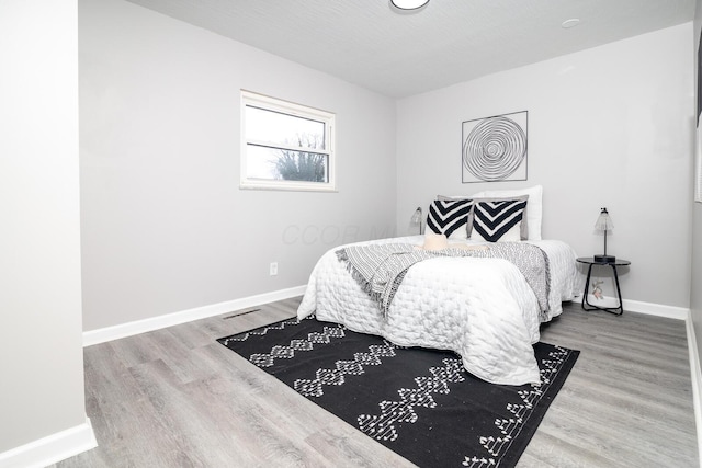 bedroom with baseboards and wood finished floors