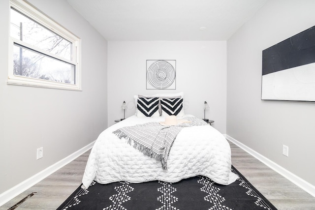 bedroom with wood finished floors and baseboards