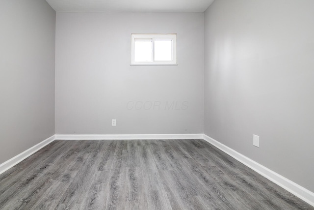 empty room with baseboards and wood finished floors