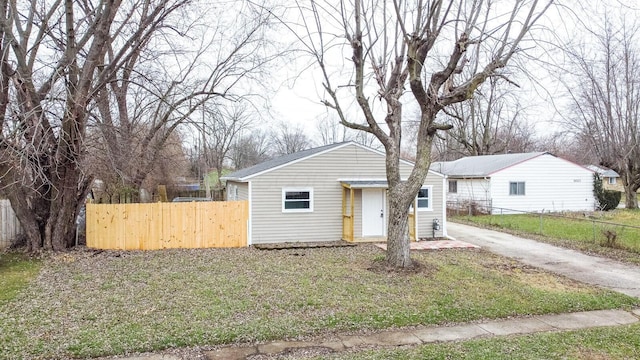 bungalow featuring driveway and fence