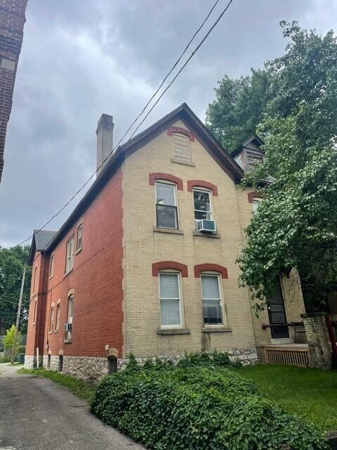 view of home's exterior with a chimney and brick siding