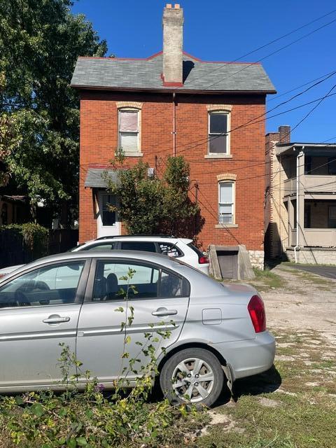 view of side of home with a chimney and brick siding