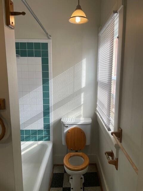 bathroom with tub / shower combination and toilet