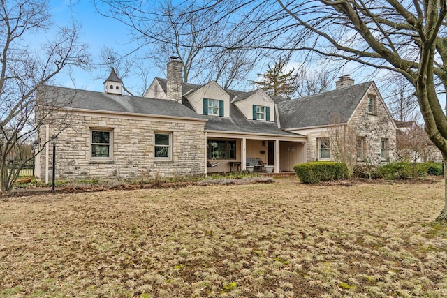 cape cod home featuring a porch and a chimney